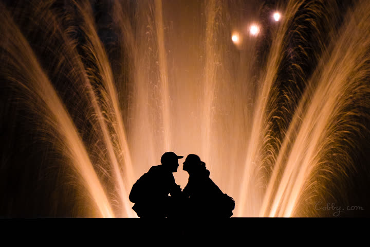 Silhouette of a couple in front of an illuminated fountain at night, Brussels