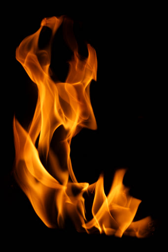 Flames: a tall orange flame on a black background