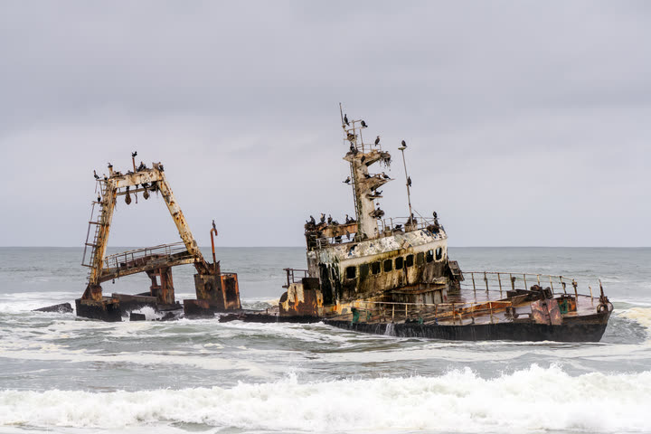Rusting shipwreck in the surf of the Skeleton Coast