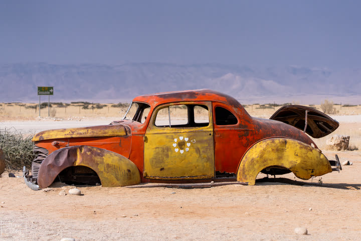 Rusty abandoned car wreck in the desert at Solitaire