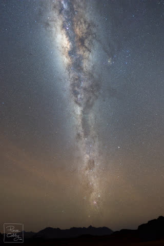 The Milky Way rising vertically above the mountains of the Namibian desert