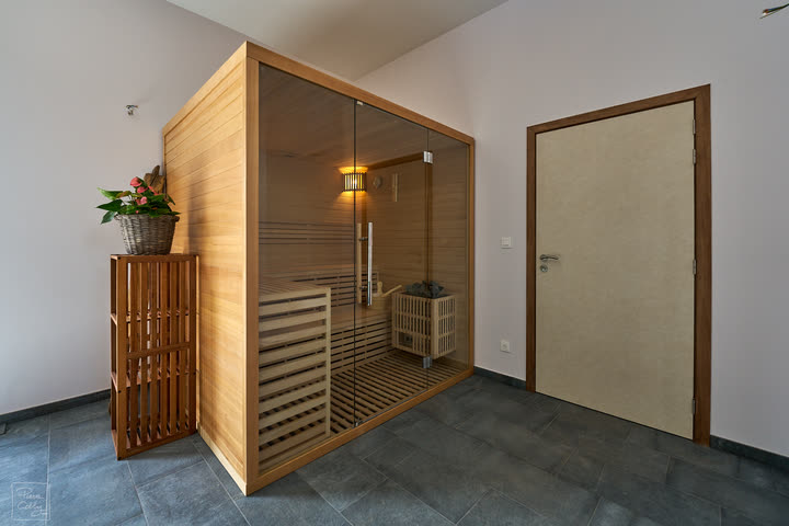 Wooden sauna cabin with a plant on a slatted stand