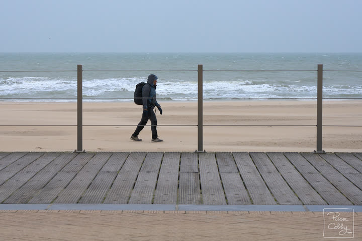 Hiker walking along the boardwalk by the sea, Ostend