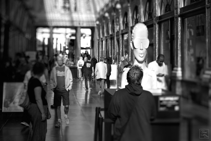 Mannequin bust with sunglasses among passers-by in the Galeries Royales Saint-Hubert, Brussels